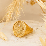Rachel Ring placed on a warm-toned textured surface with dried wheat for soft, natural styling