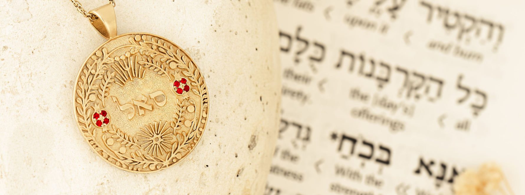 Woman holding a handcrafted 14k gold pendant with Hebrew inscription – symbolic Jewish jewelry representing protection and spiritual meaning