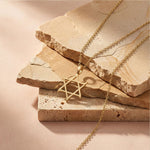 Curved Star of David Necklace in 18K Gold Vermeil displayed on stacked stone tiles