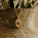 Close-up of the Window to the Soul pendant detail, showcasing the intricate radiating gold lines and brilliant sapphire stone.