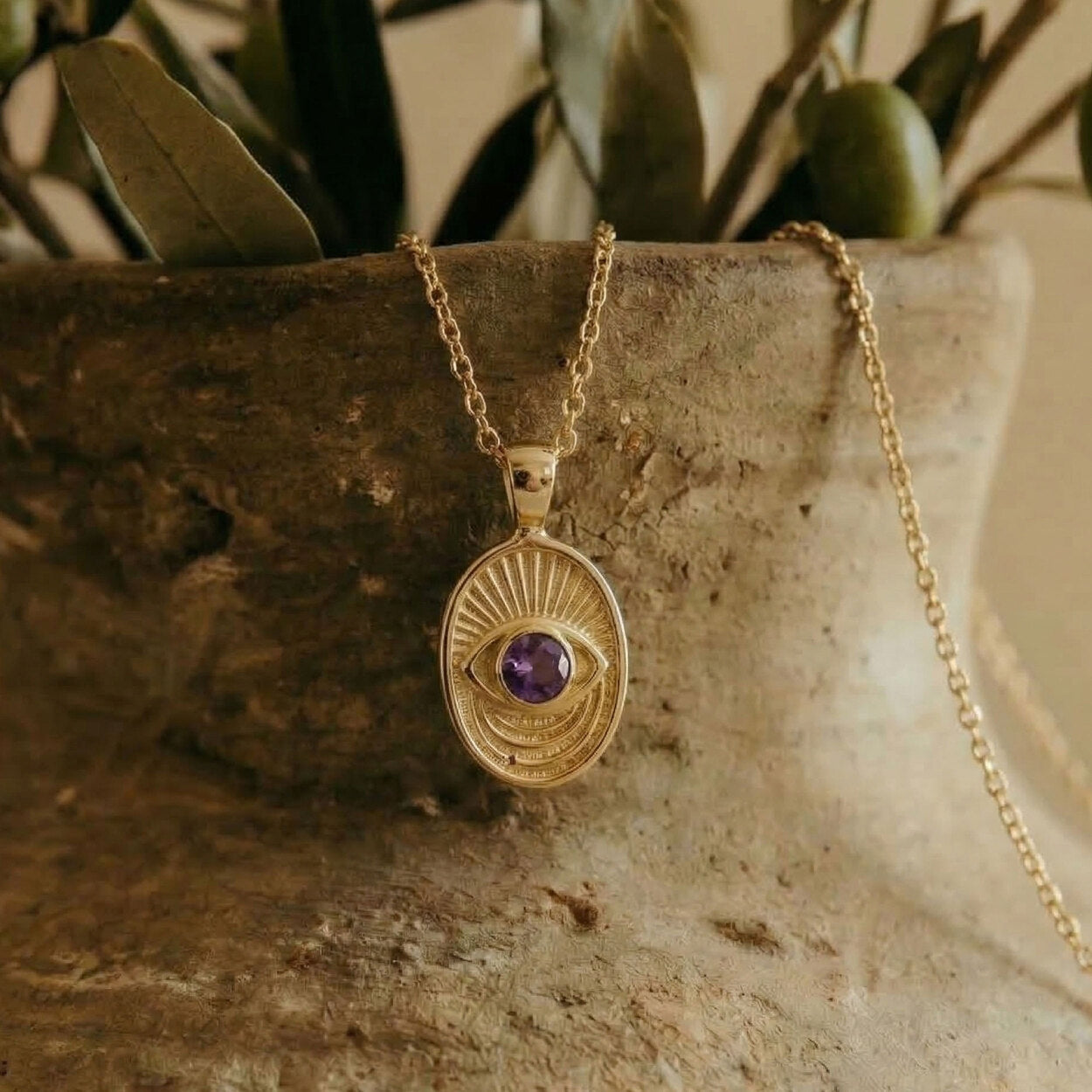 Close-up of the Window to the Soul pendant detail, showcasing the intricate radiating gold lines and brilliant sapphire stone.