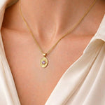 A woman wearing the Divine Eye gold necklace, a celestial-inspired talisman for guidance and protection.
