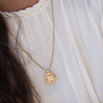 ה ה ע pendant on dual chain against linen backdrop
