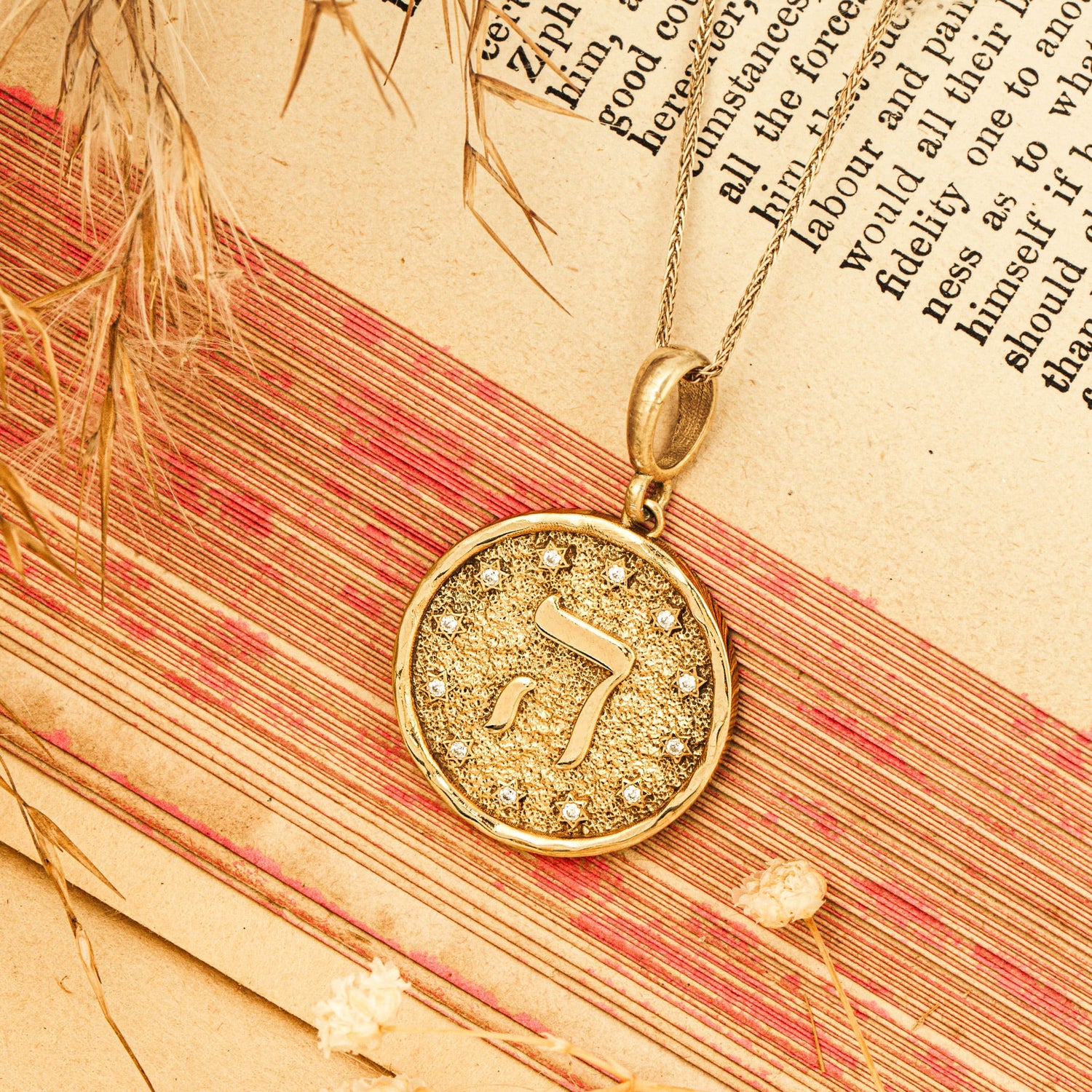Hey pendant resting on vintage scroll warm red tones