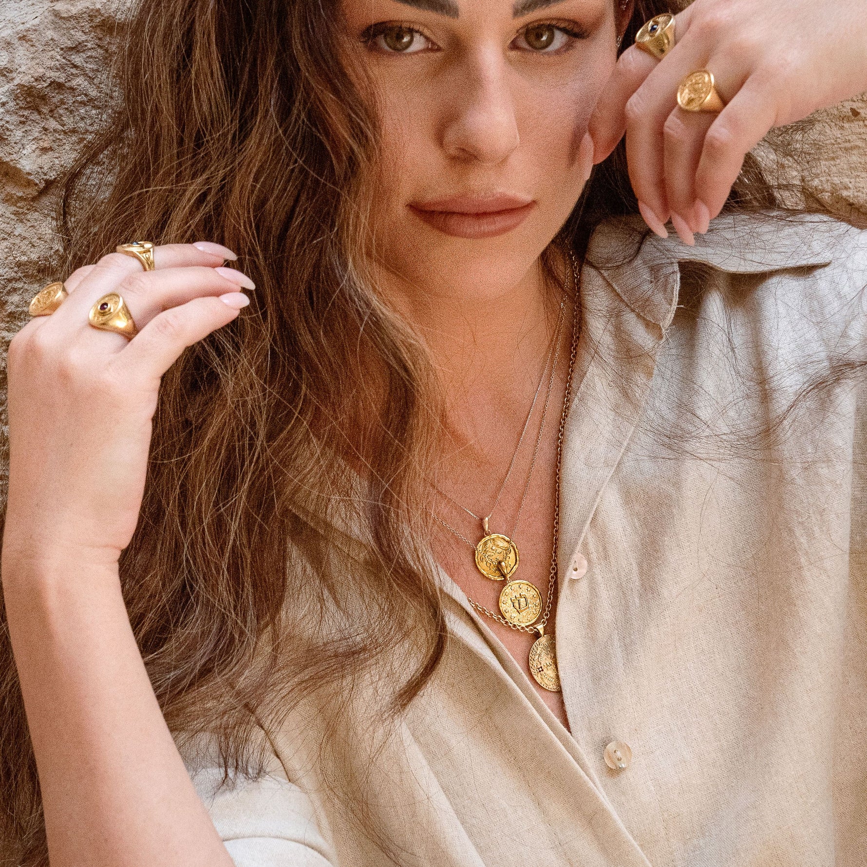 Shin pendant styled on model against stone wall 