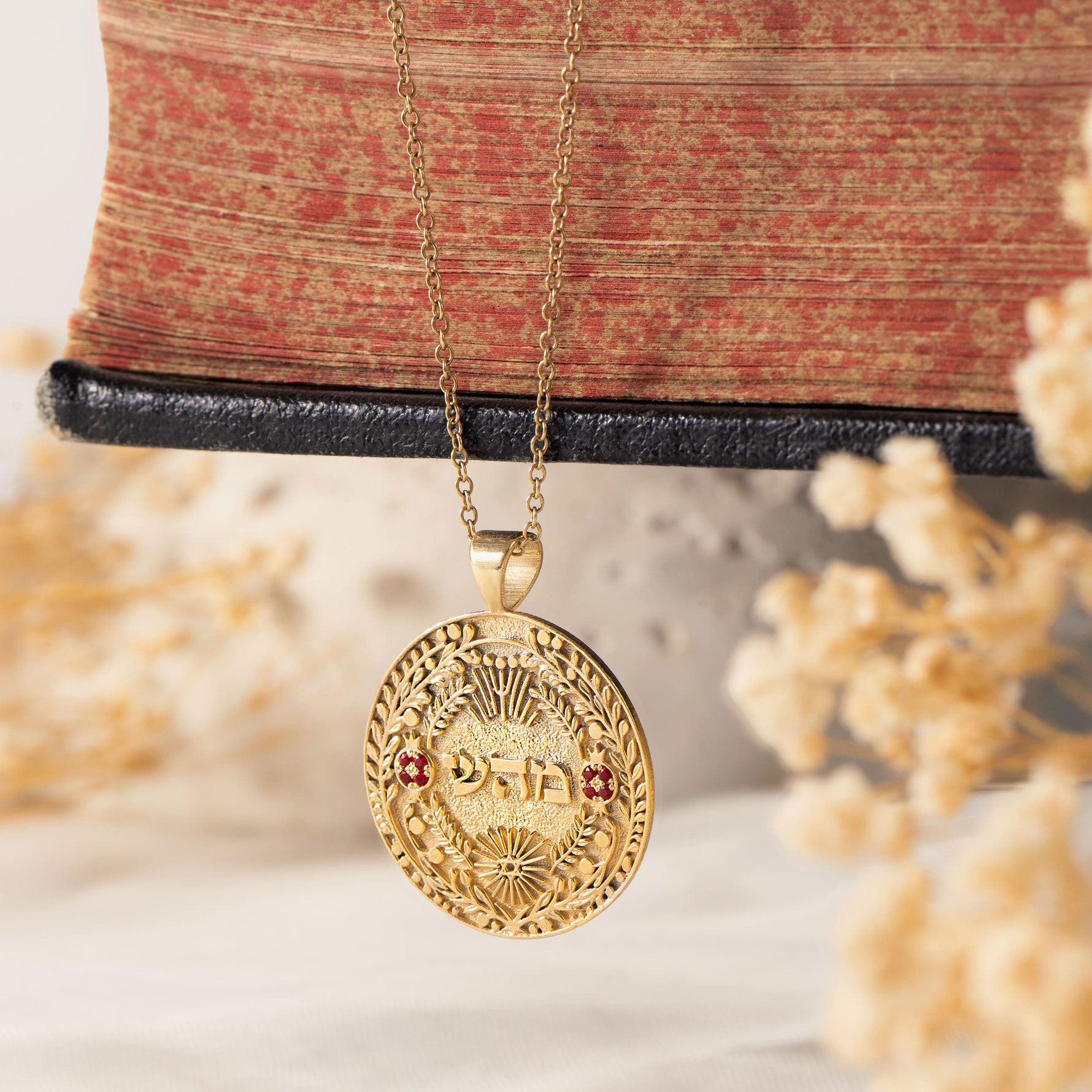 מהש pendant hanging against antique book with florals