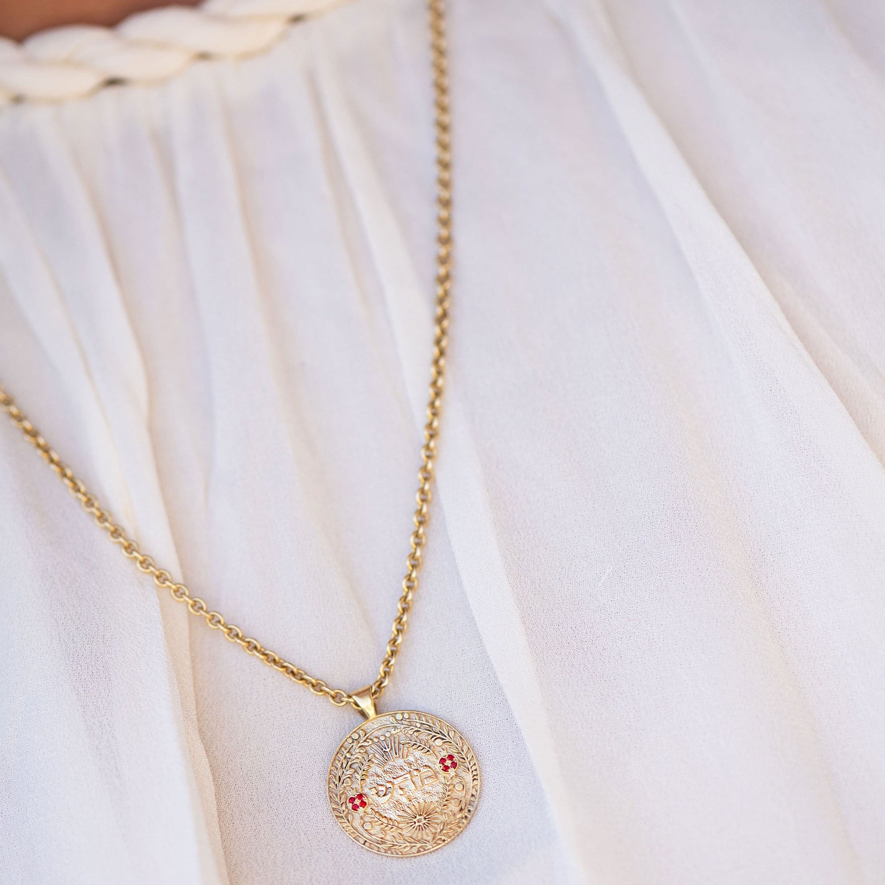 מהש pendant layered with necklaces on model’s chest