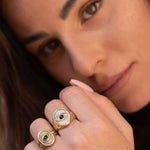 Model wearing Protective Eye Ring, hand near face, showcasing symbolic detailing