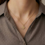 Classic Star of David coin necklace in 18K gold vermeil worn by a model with a soft neutral blouse.