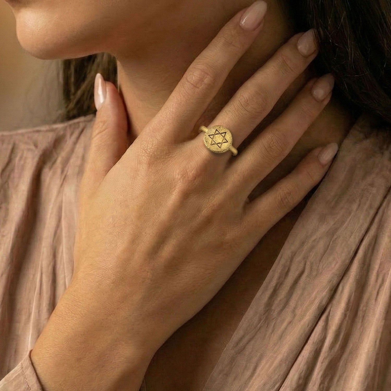 Classic Star of David coin ring in 18K gold vermeil worn on a model’s hand with a soft neutral blouse.