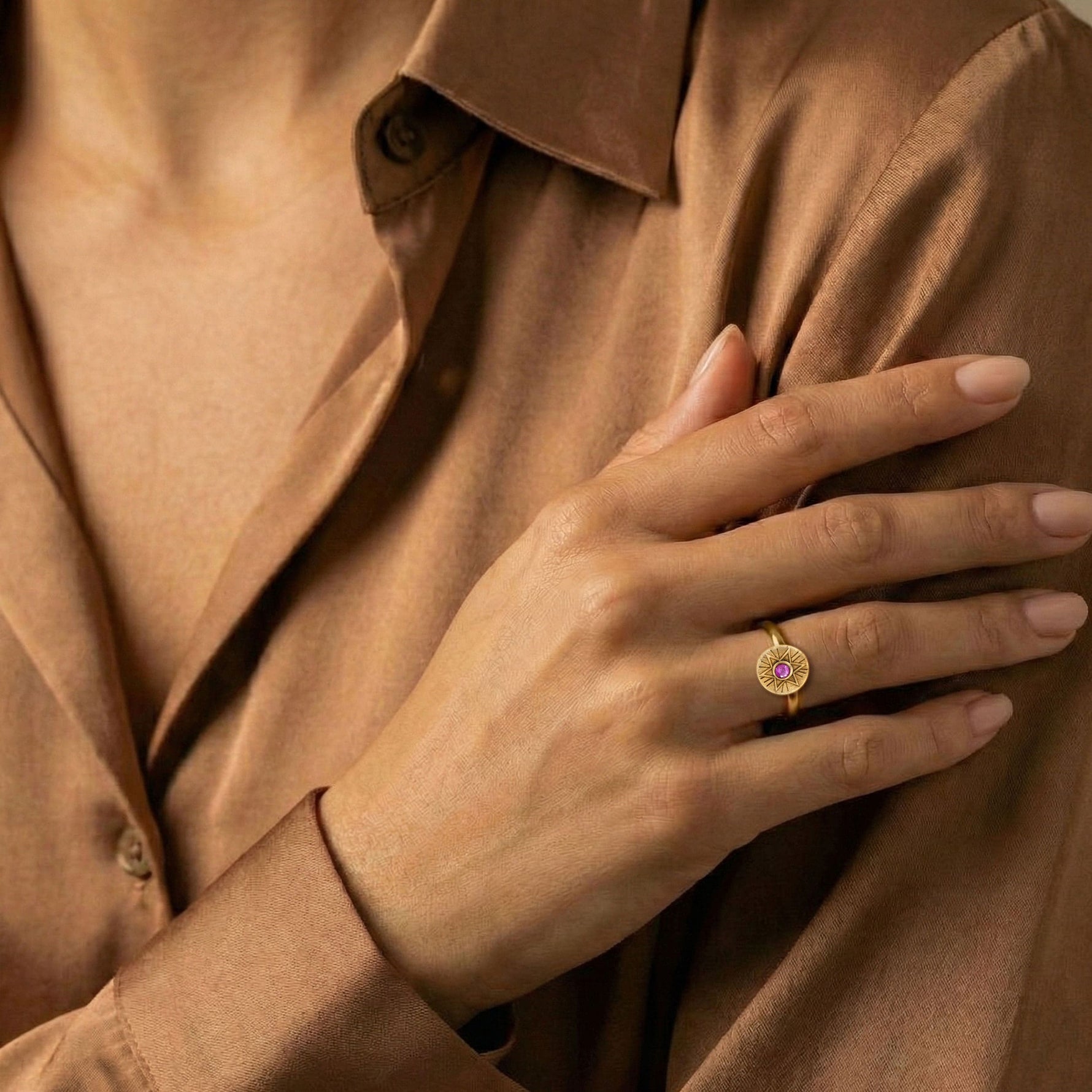 Woman wearing the Radiant Star of David ring in 18K gold vermeil with a pink sapphire, styled on the hand.