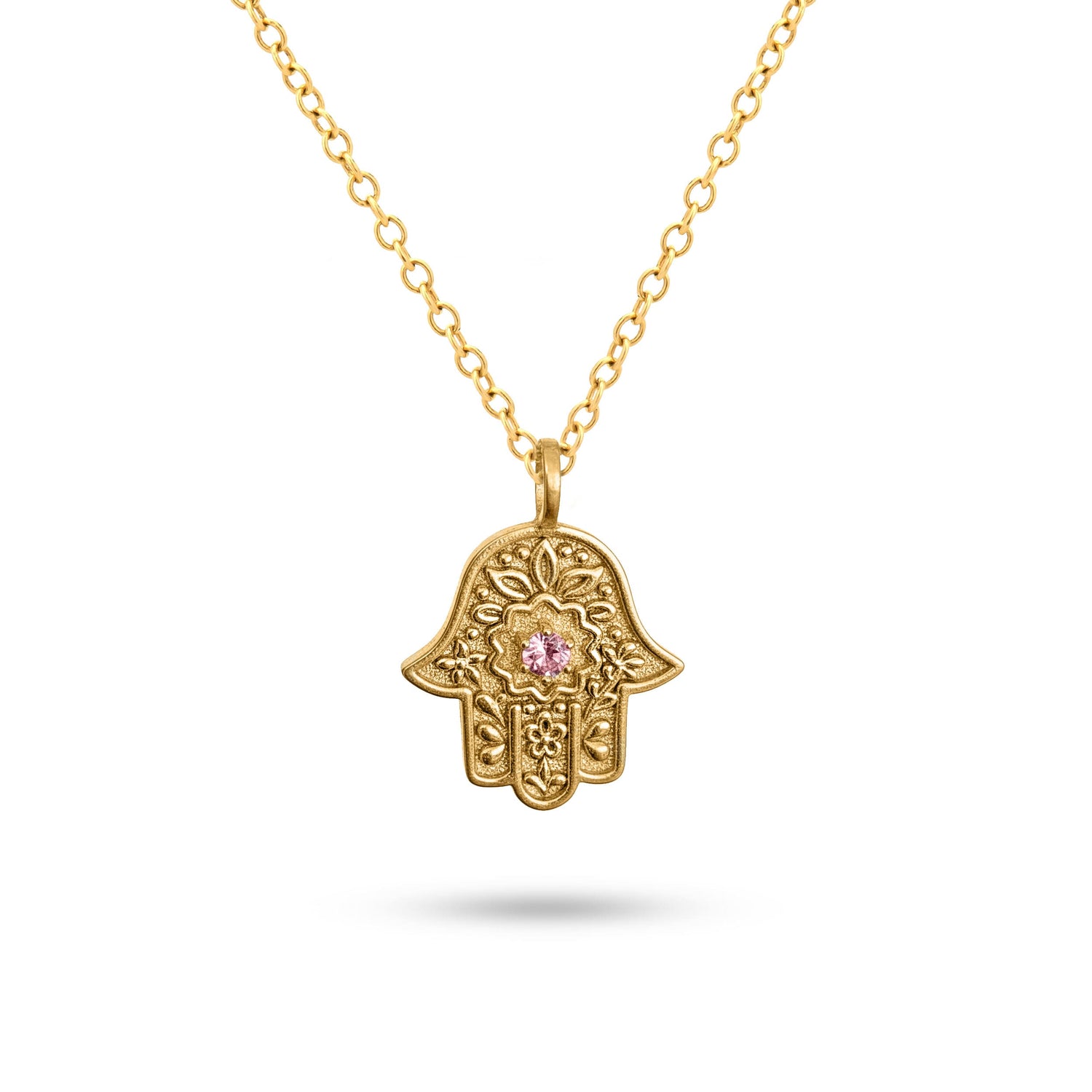 Detailed view of the embossed floral motif on the gold Garden of Grace Hamsa.