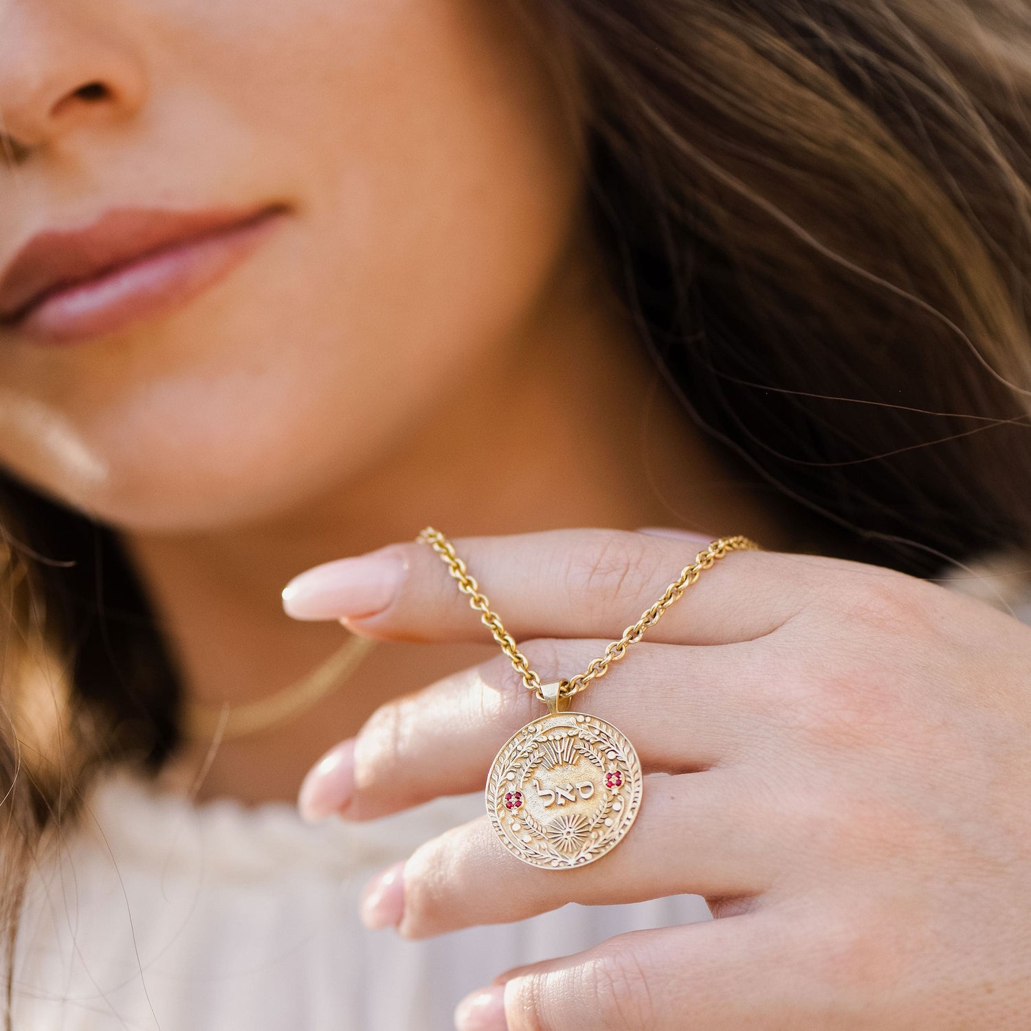 Model wearing סאל pendant necklace layered with rings