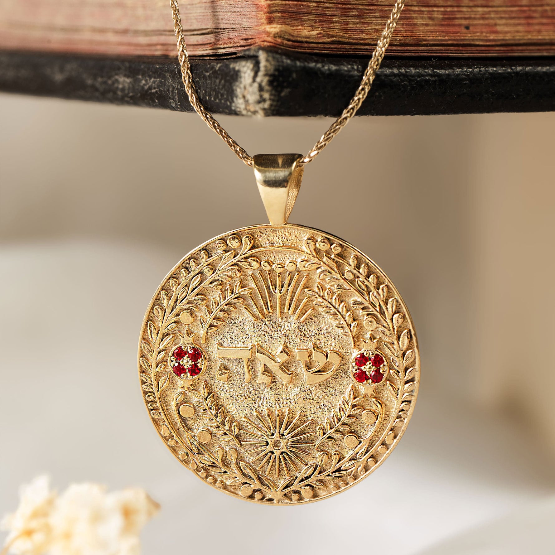 שאה pendant hanging on wooden book spine dried flowers