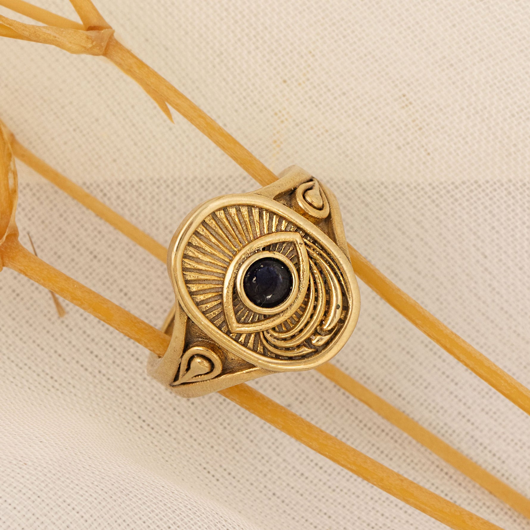 Window to the Soul gold ring with black gemstone styled on soft natural fabric – Sages & Souls