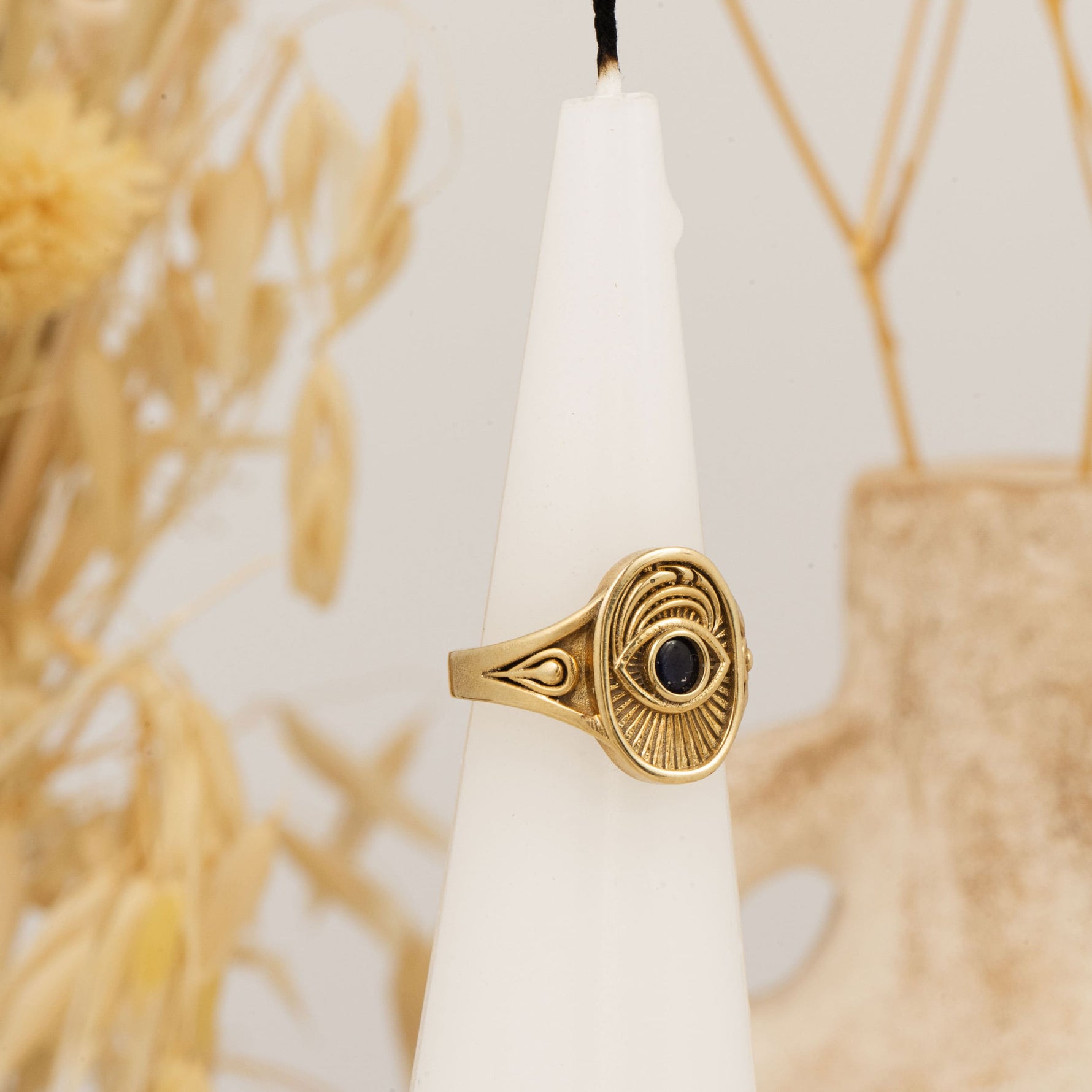Window to the Soul Ring placed upright on white candle with dried florals