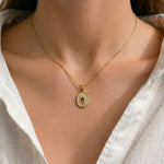 A woman wearing the Window to the Soul gold necklace, showing the elegant scale and spiritual presence of the eye pendant.